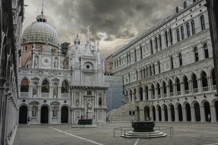 Explore the architectural grandeur of Doge's Palace courtyard in Venice under dramatic skies.
