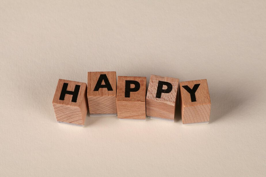 Wooden blocks with the word 'Happy' on a light neutral background. Perfect for themes of joy and positivity.
